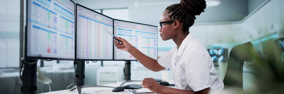 Mulher analisando planilhas no computador. ciencias-contabeis.
