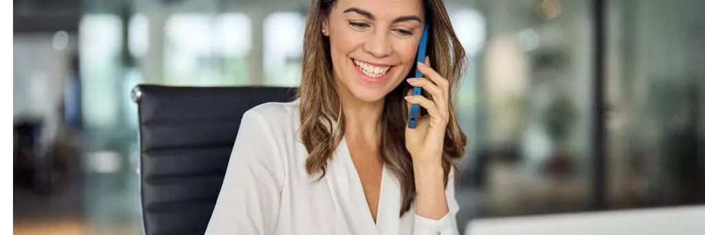 secretária sorrindo e falando ao celular