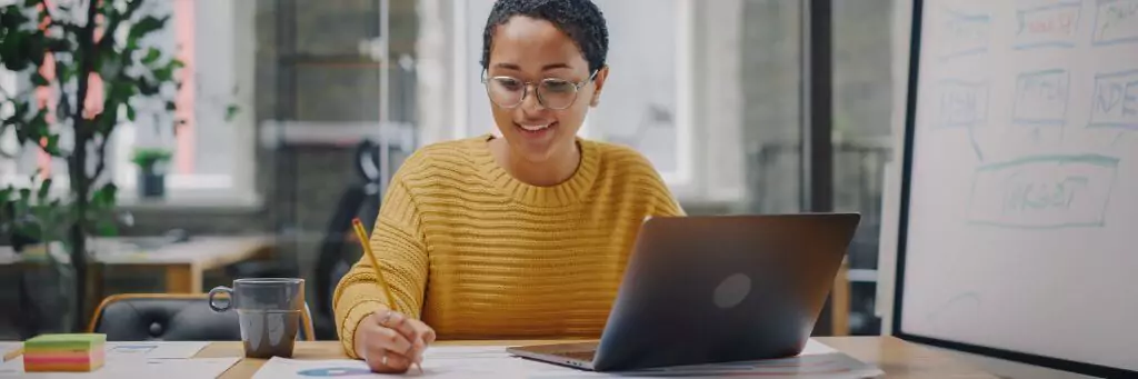moça em escritório trabalhando com computador e gráficos