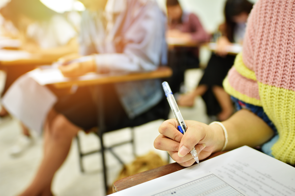 Jovens fazendo prova em sala de aula. Redação enem.